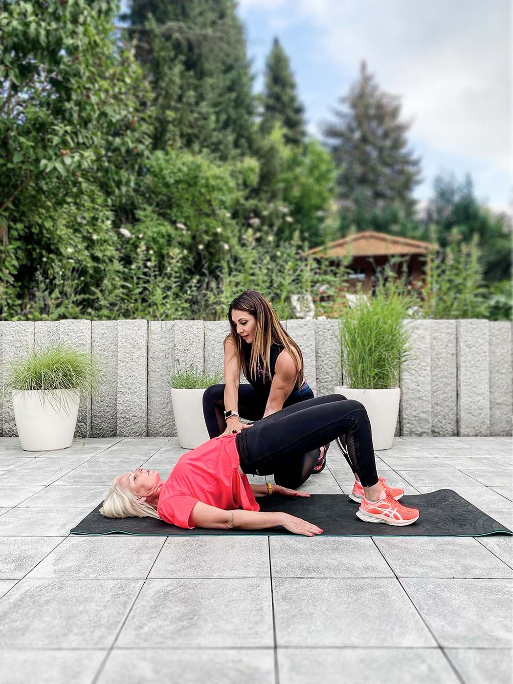 Personaltraining im Garten: Dehnübung mit Unterstützung