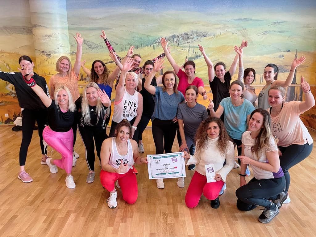 Teilnehmerinnen des HIIT the Beat Charity Workouts mit der Spendenurkunde